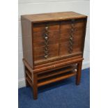 AN EARLY 20TH CENTURY OAK TAMBOUR FRONT BANK OF SIXTEEN DRAWERS, with brass label slots/handles,