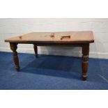 AN EDWARDIAN OAK WIND OUT DINING TABLE, with canted corners, on additional lead, on fluted legs,