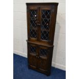 A MODERN OAK LEAD GLAZED FOUR DOOR CORNER CUPBOARD