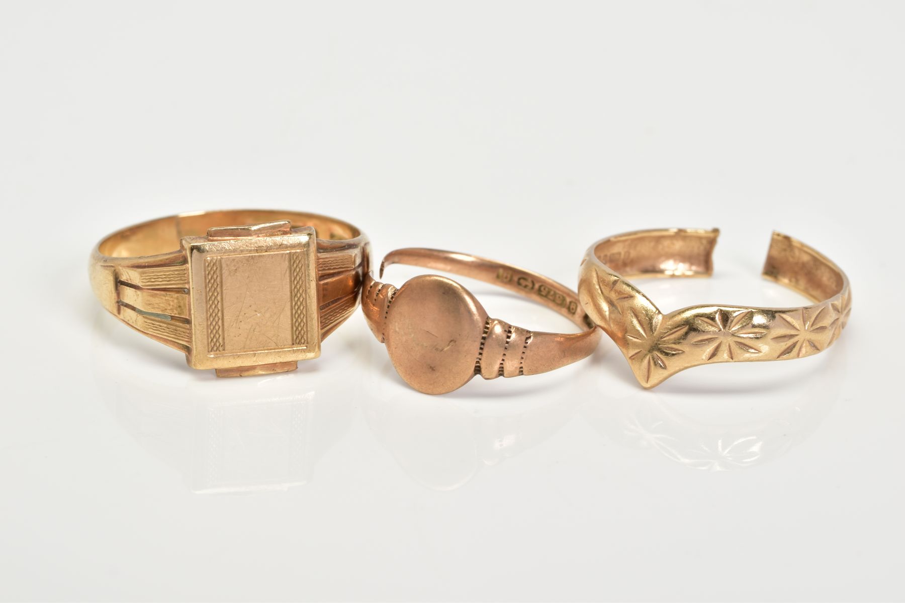 THREE 9CT GOLD RINGS, to include a square panel signet ring, with a 9ct hallmark for Birmingham,