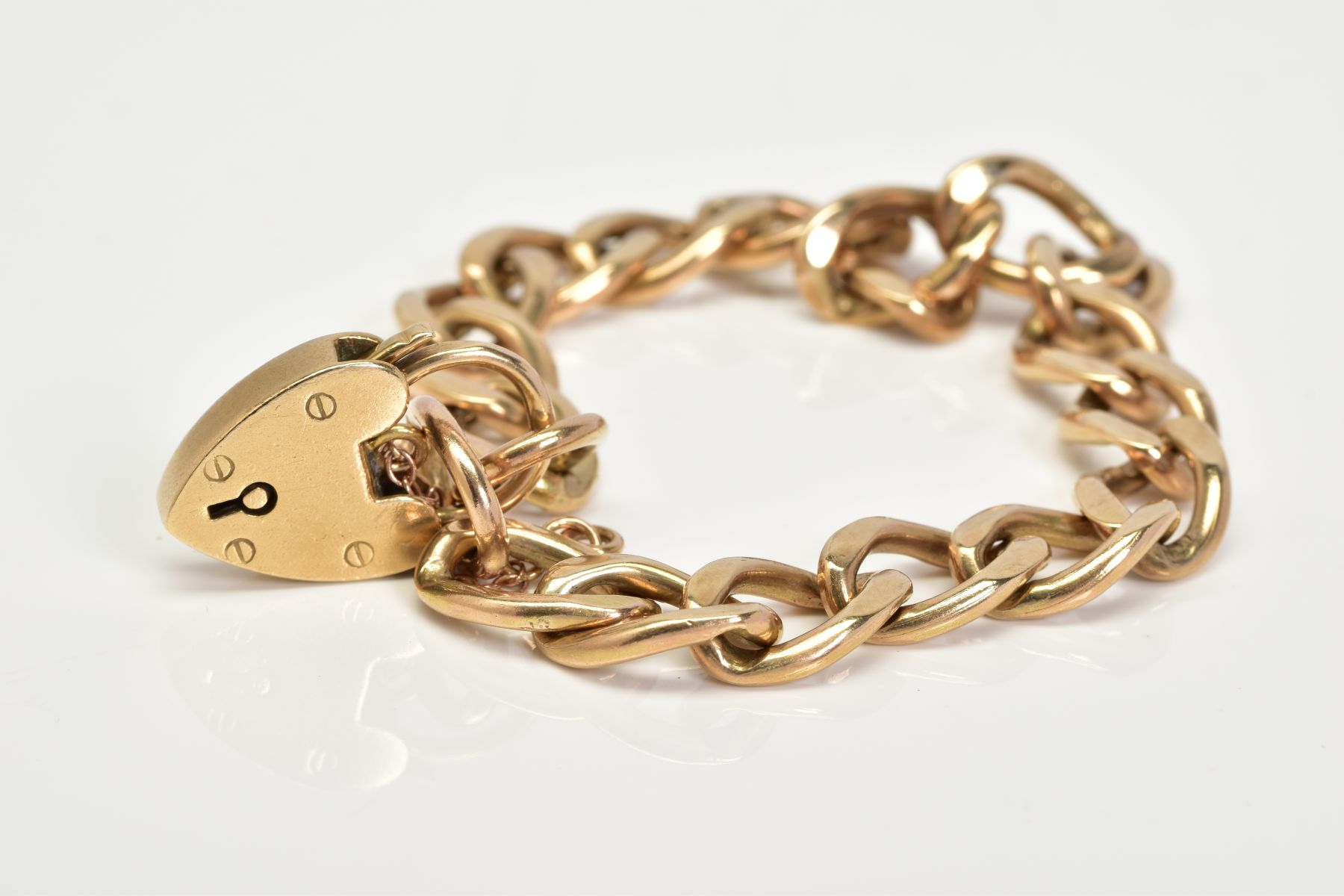 A 9CT GOLD CHARM BRACELET, of curb link design with each link stamped 3.975, to a heart clasp with a