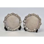 A NEAR PAIR OF GEORGE III SILVER CIRCULAR WAITERS, shell and pie crust borders, the centres engraved