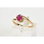 A 9CT GOLD RUBY AND DIAMOND RING, the openwork crossover design, with a central claw set oval cut