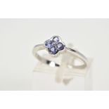 A 9CT WHITE GOLD AND TANZANITE RING, designed as a flower set with four circular cut tanzanite