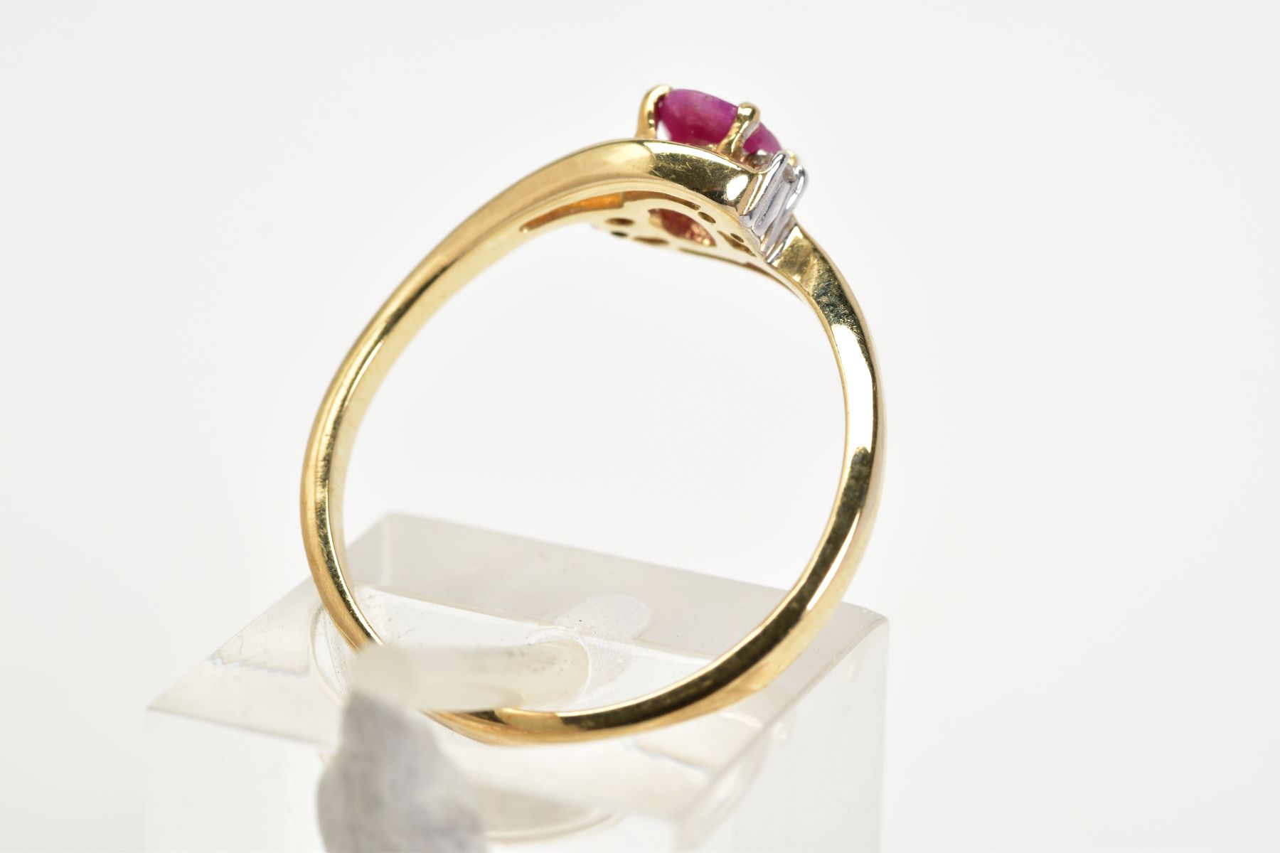 A 9CT GOLD RUBY AND DIAMOND RING, the openwork crossover design, with a central claw set oval cut - Image 3 of 3