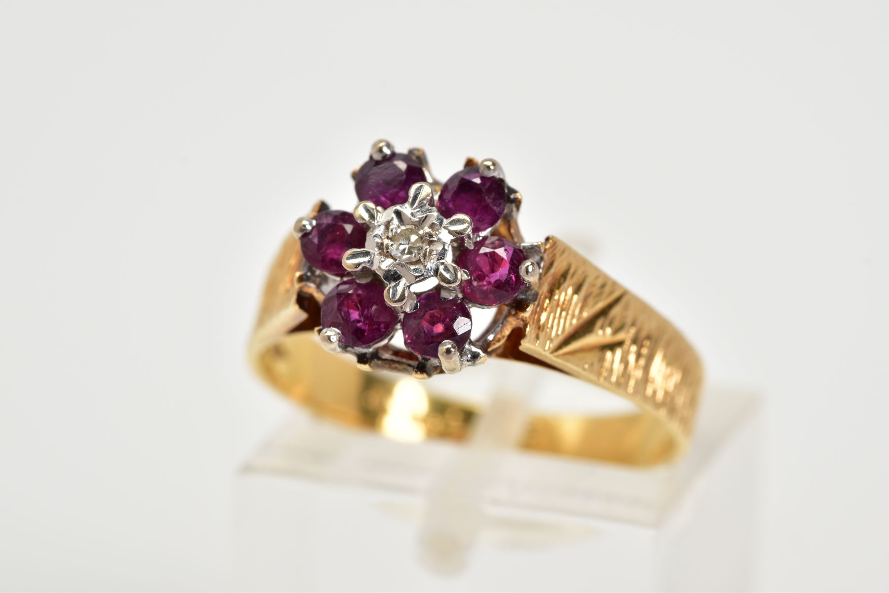 AN 18CT GOLD GARNET AND DIAMOND CLUSTER RING, the tiered cluster set with a central single cut