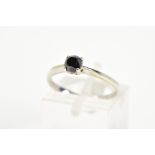 A 9CT WHITE GOLD BLACK DIAMOND RING, designed with a central claw set black round brilliant cut