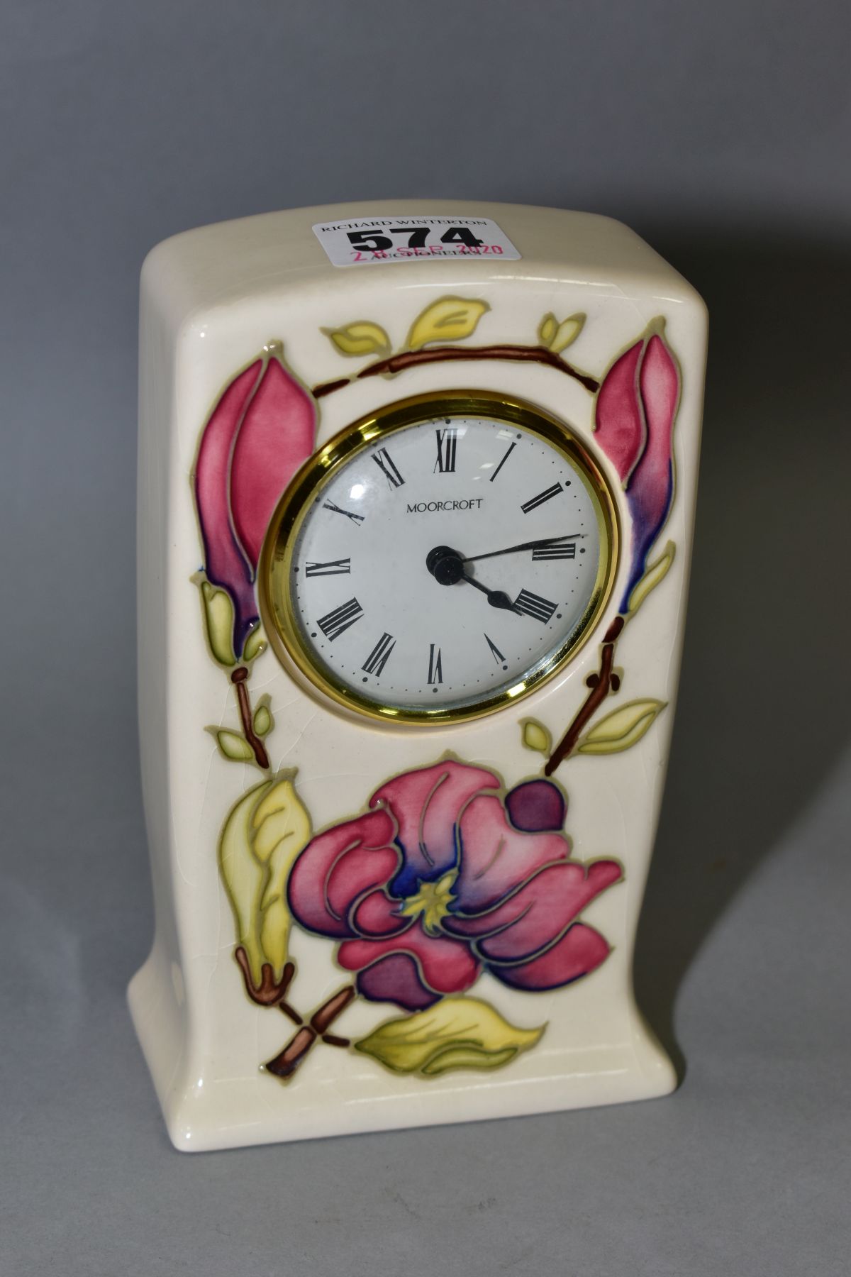 A MOORCROFT POTTERY QUARTZ MANTEL CLOCK, pink magnolia design on a cream ground, impressed and