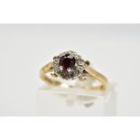 A 9CT GOLD GARNET AND DIAMOND CLUSTER RING, set with a central circular cut garnet with a round