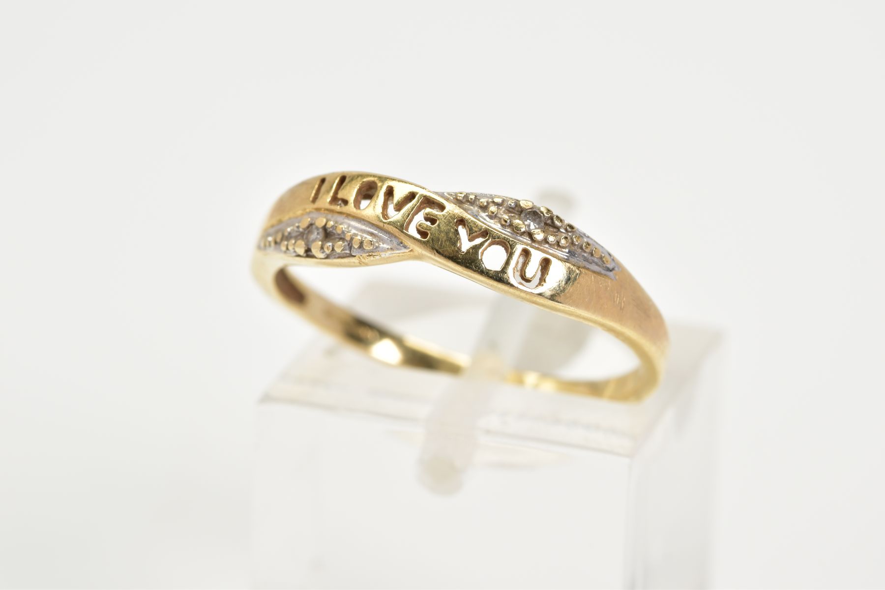 A 9CT GOLD CROSSOVER RING, designed with an open work panel with the word 'I Love You' flanked