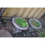 A PAIR OF COMPOSITE GARDEN URNS with fluted detail to bowl standing on a square base, diameter