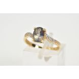 A 9CT GOLD TOPAZ AND DIAMOND RING, designed with a claw set oval cut coated topaz (mystic topaz)