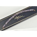 AN AMETHYST AND DIAMOND BRACELET, designed with eight panels with two rows of oval cut amethyst,