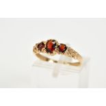 AN EARLY 20TH CENTURY GARNET RING, set with three graduated oval cut garnets claw set to the