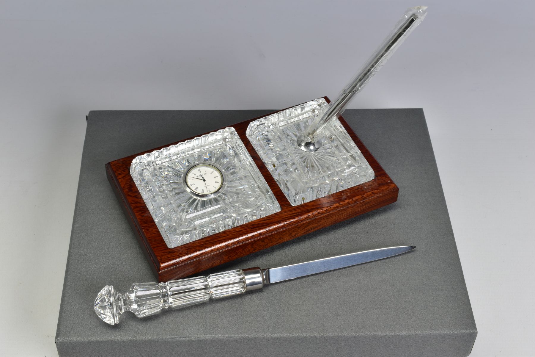 A BOXED WATERFORD CRYSTAL DESK SET, comprising a quartz clock and a pen stand with pen set in a