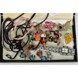 A SELECTION OF COSTUME JEWELLERY, to include two white metal charm bracelets with charms, a pink