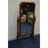 A LATE VICTORIAN WALNUT CHEVAL MIRROR, with canted top corners, supported on twin supports with