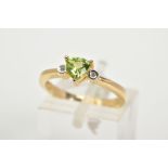 A 9CT GOLD PERIDOT AND DIAMOND RING, set with a central claw set, triangular cut peridot flanked
