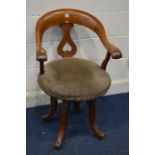 AN EARLY 20TH CENTURY OAK SWIVEL ARMCHAIR, on four outsplayed legs