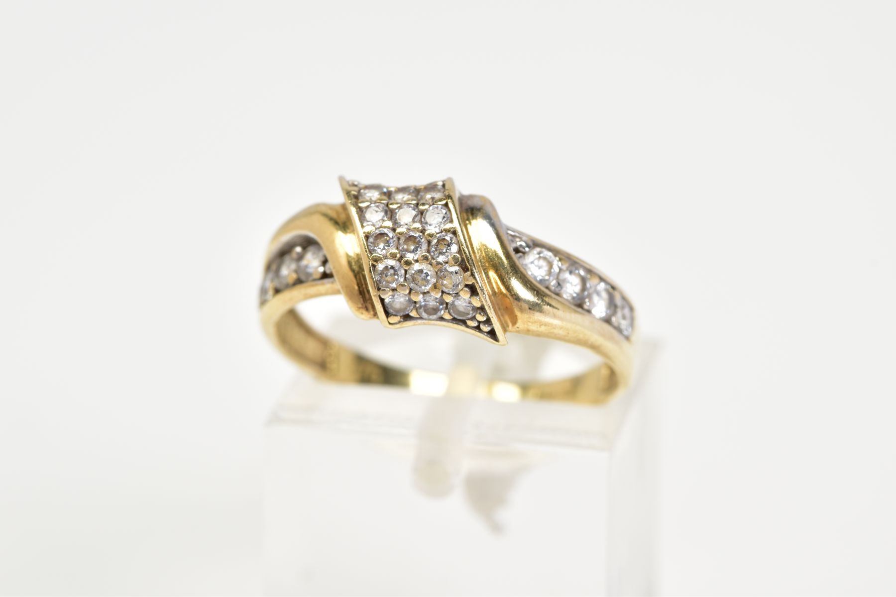 A 9CT GOLD DIAMOND RING, designed with an asymmetrical panel set with round brilliant cut