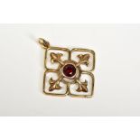 AN EDWARDIAN OPENWORK PENDANT, the openwork pendant set with a central circular cut garnet, Fleur De