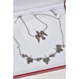 TWO WHITE METAL PENDANT NECKLACES, to include a foliage designed panel necklace each leaf link set