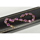 A 9CT GOLD LINE BRACELET, set with fourteen oval mix cut pink sapphires, each within a collet mount,