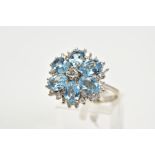 AN 18CT WHITE GOLD AQUAMARINE AND DIAMOND CLUSTER RING, the large tiered cluster set with central