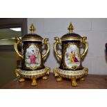 A PAIR OF EARLY 20TH CENTURY COALPORT TWIN HANDLED URNS AND COVERS WITH HAND PAINTED PANELS OF