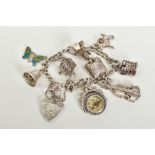 A SILVER CHARM BRACELET, with eight attached charms such as a small fob compass, violin, bell,