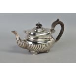 AN EDWARDIAN SILVER BACHELOR'S TEAPOT, of oval form, shell and gadrooned rim, stop reeded body, four