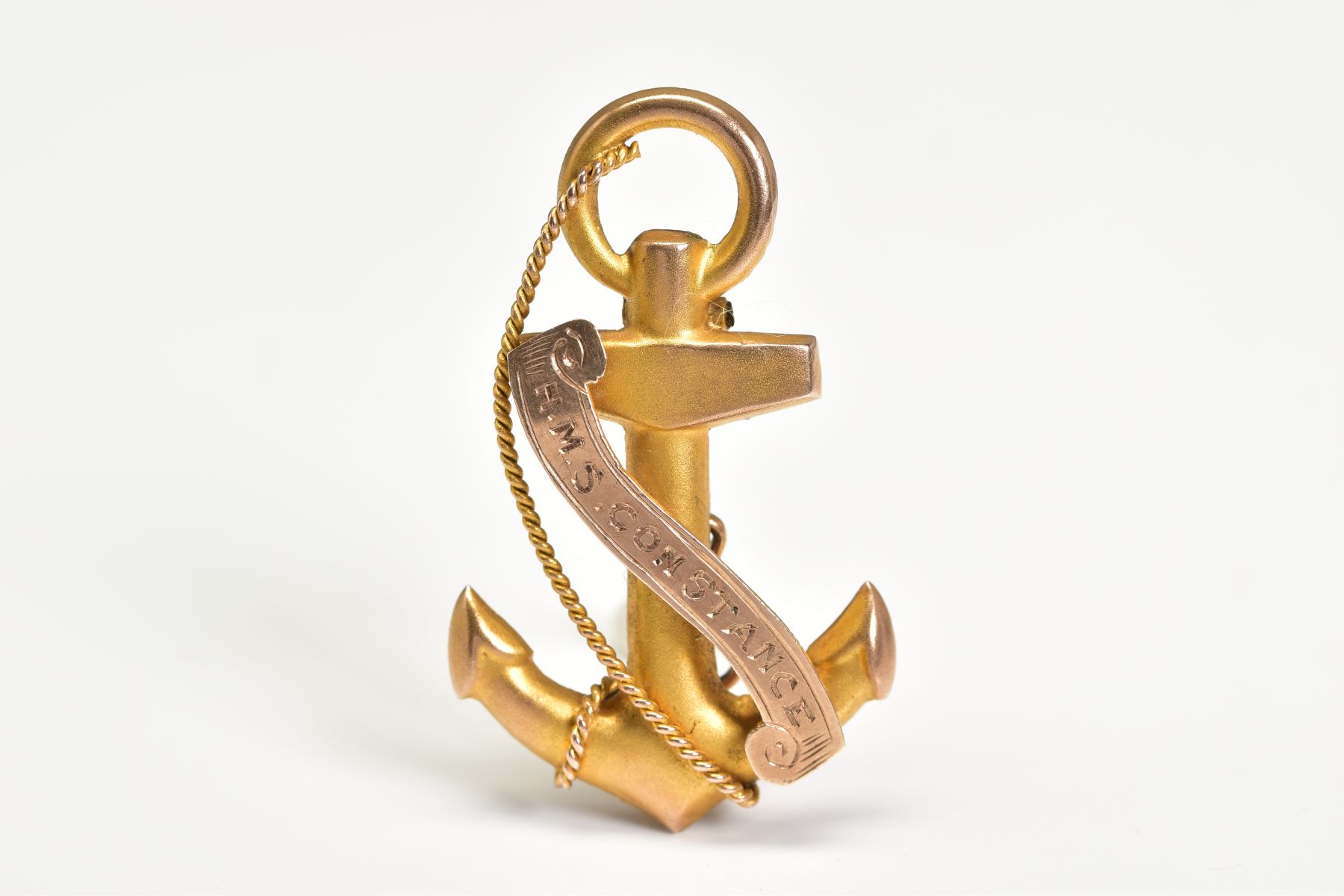 A YELLOW METAL VICTORIAN BROOCH, in the form of an anchor and rope with engraved scroll 'H.M.S.