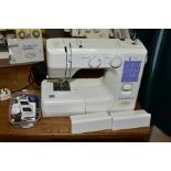 A JANOME SEWING MACHINE AND ATTACHMENTS, having a selection of embroidery stitches (no power cable