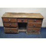A DISTRESSED VICTORIAN PINE SIDEBOARD, with seven drawers, width 159cm x depth 59cm x height 78cm