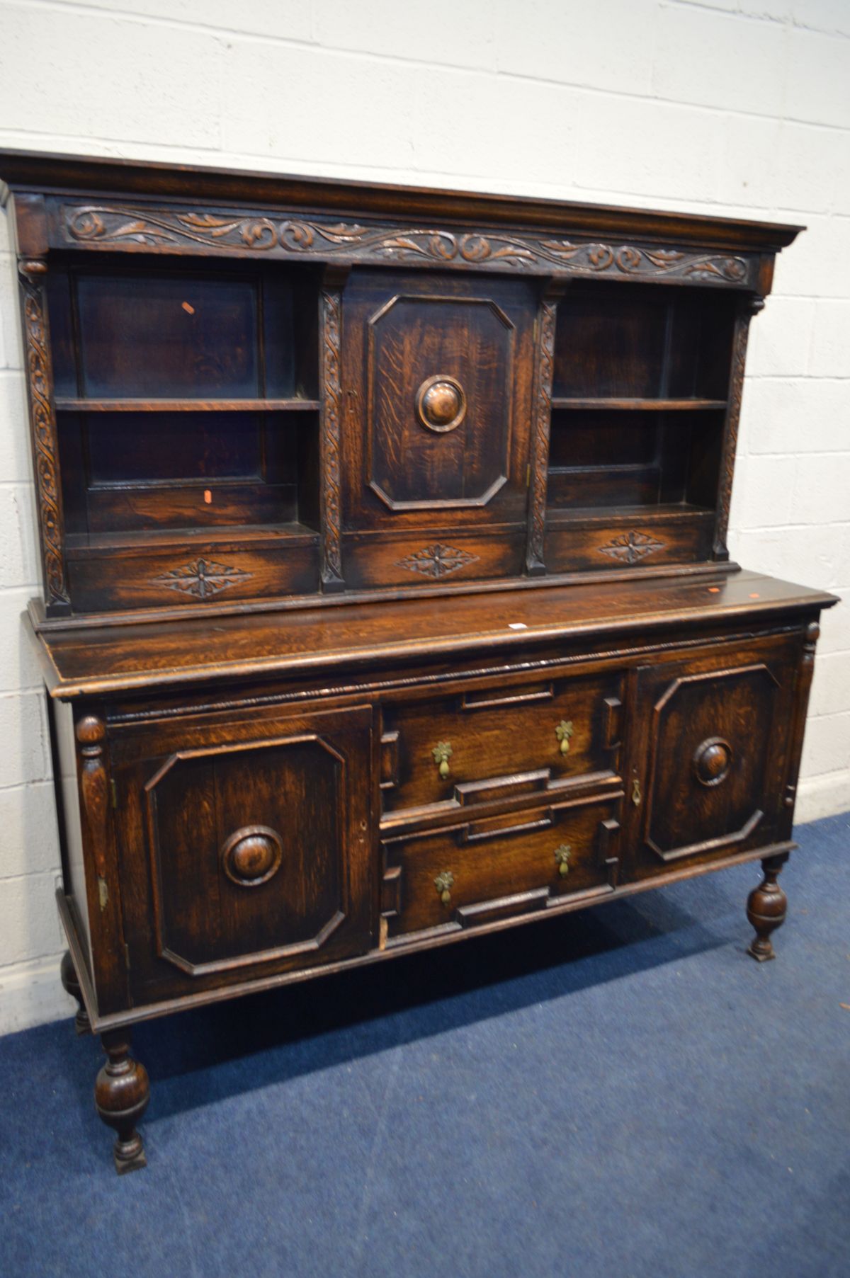 AN EARLY 20TH CENTURY OAK DRESSER, the top section with two open shelves flanking a single