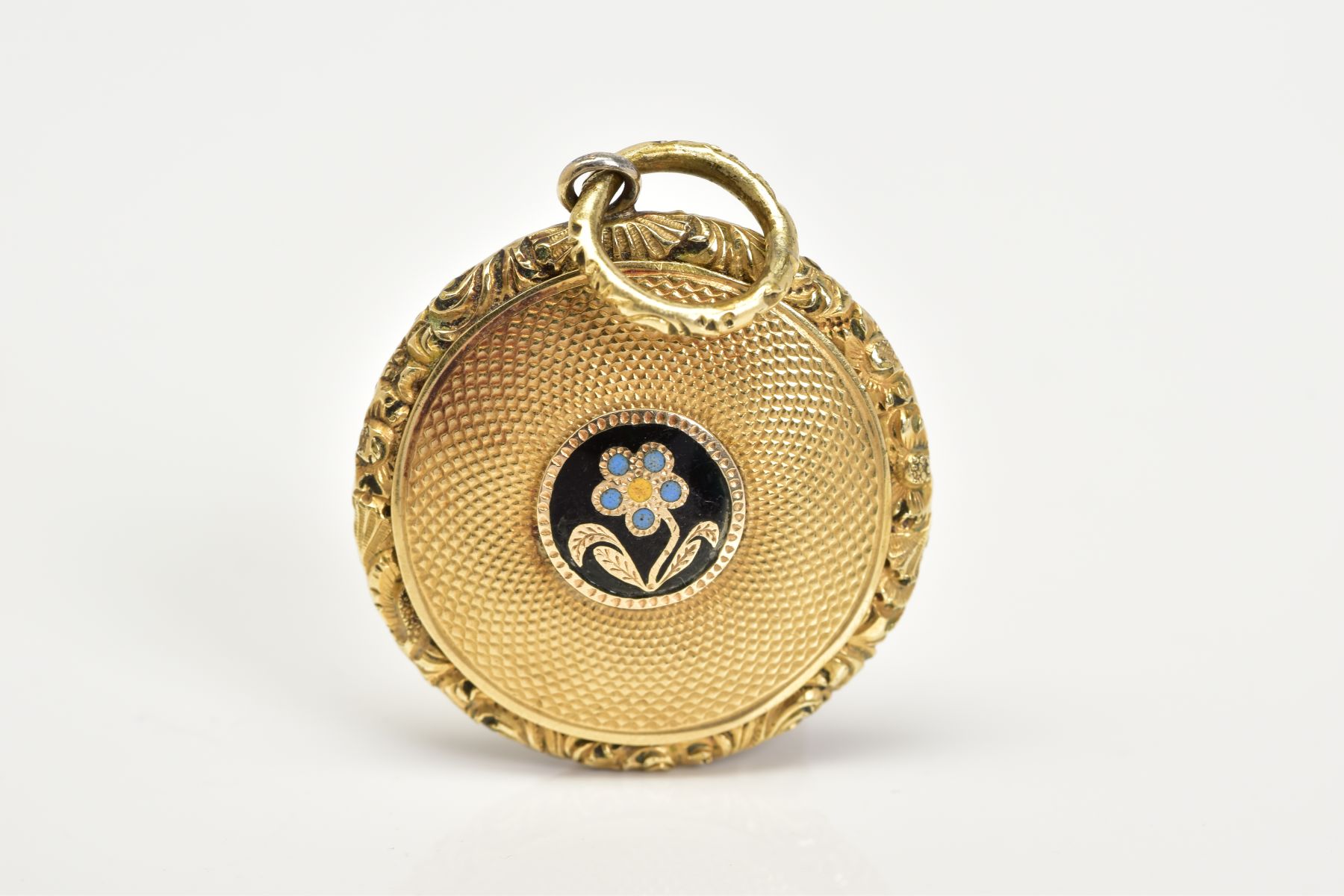 A YELLOW METAL MEMORIAL PENDANT, of circular design, central black, blue and yellow enamel flower