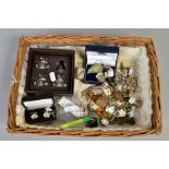 A WICKER BASKET OF JEWELLERY AND ITEMS, to include ten white metal necklaces such as leaf design