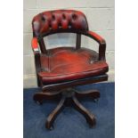 A MAHOGANY OXBLOOD LEATHER SWIVEL OFFICE OPEN ARMCHAIR, on casters