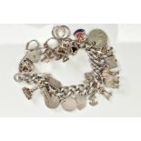 A WHITE METAL CHARM BRACELET, suspending twenty two charms such as an elephant, rocking chair, keys,