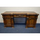 A LATE 19TH CENTURY OAK PEDESTAL SIDEBOARD, the top with carved edging and four half rounded pillars