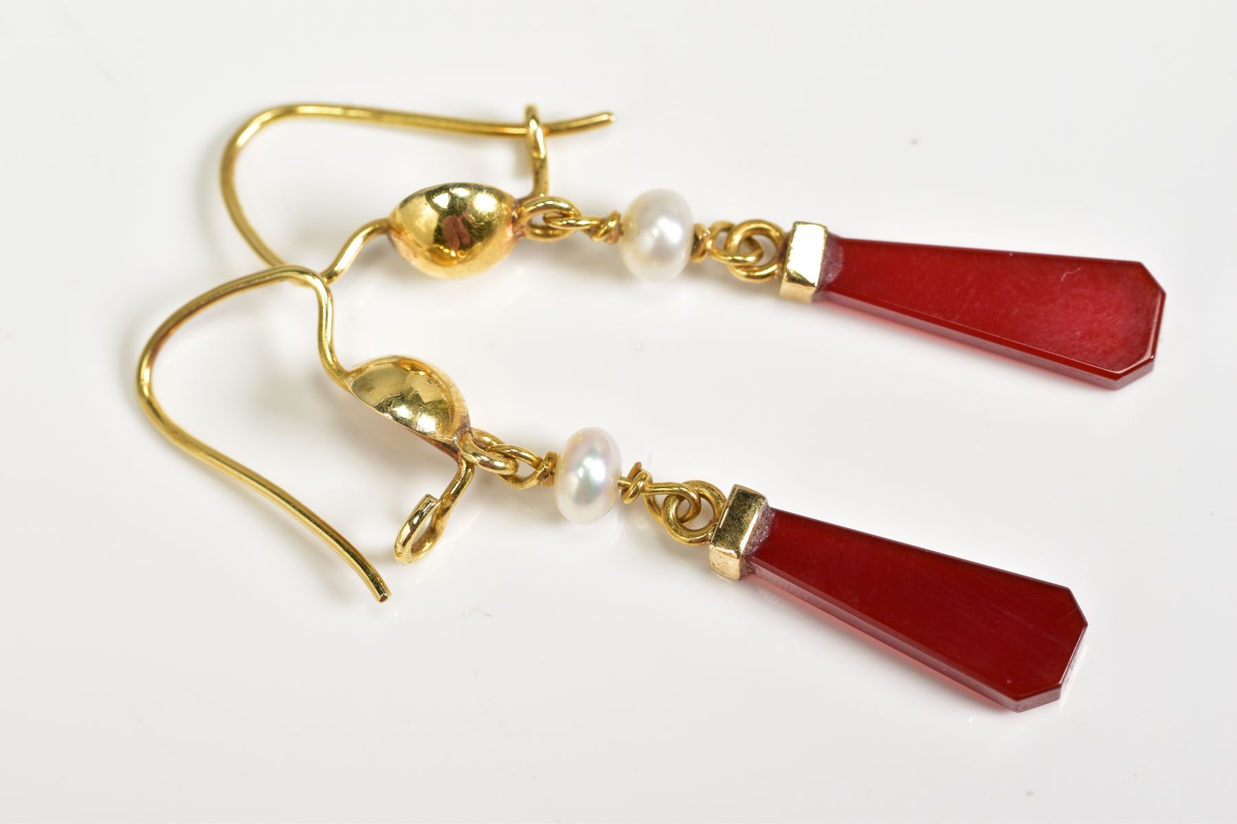 A PAIR OF CARNELIAN AND PEARL DROP EARRINGS, the yellow metal earrings each designed with a