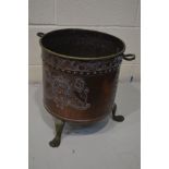 AN EARLY 20TH CENTURY BRASS AND BEATEN COPPER CYLINDRICAL LOG BUCKET with twin handles, on triple