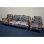 AN EARLY TO MID 20TH CENTURY MAHOGANY THREE PIECE BERGERE LOUNGE SUITE, with floral blue upholstery,