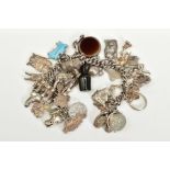 A WHITE METAL CHARM BRACELET, suspending thirty one charms such as a silver sardonyx and