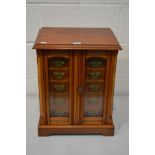 AN EDWARDIAN STYLE MAHOGANY BEVELLED GLASS TWO DOOR CABINET, revealing a bank of six drawers with