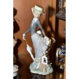 A LLADRO FIGURINE, depicting young woman in Victorian attire leaning against tree stump, holding a