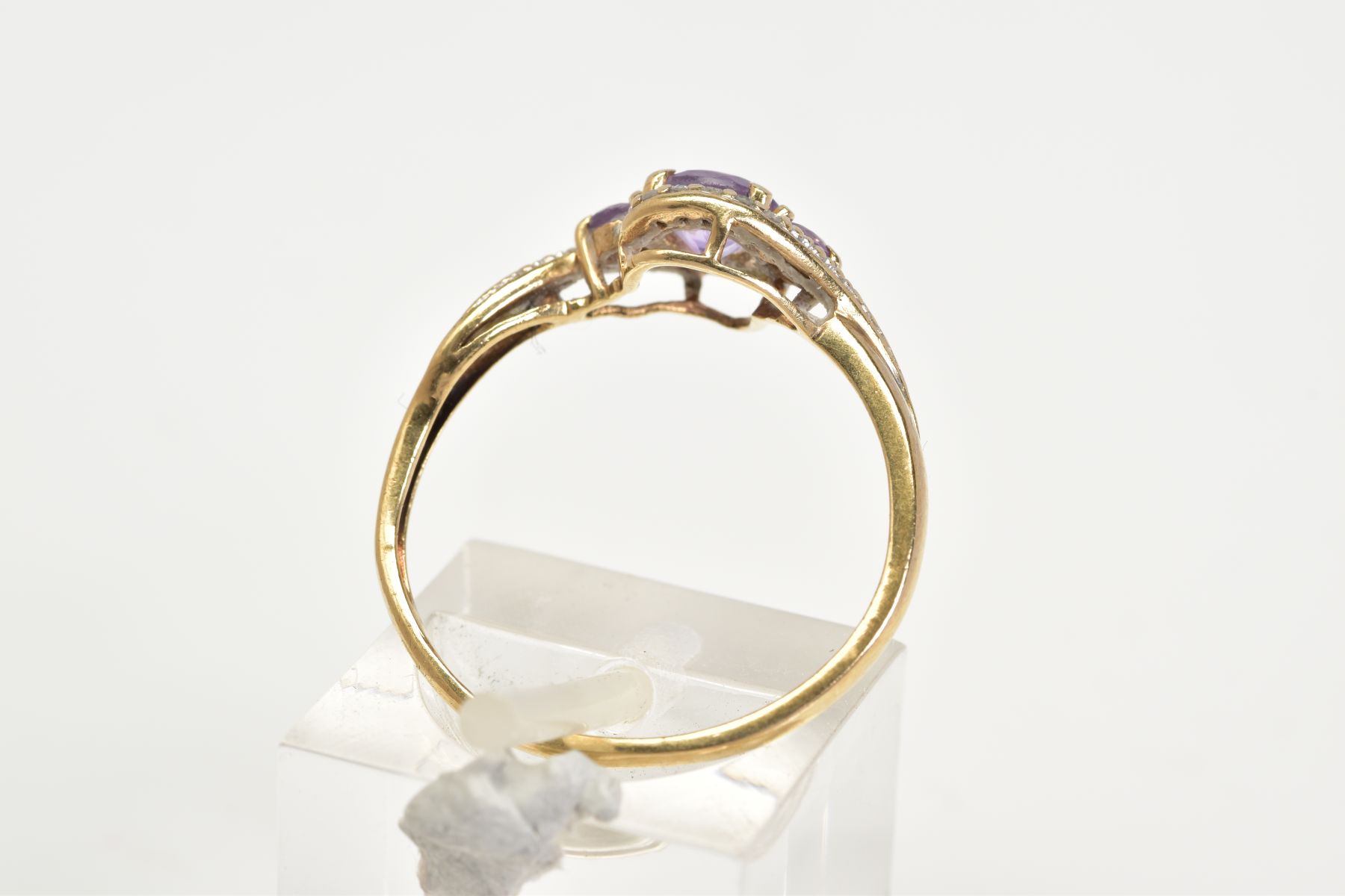 AN AMETHYST AND DIAMOND RING, the yellow metal ring of cross over design, set with three graduated - Image 3 of 3