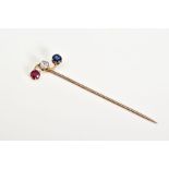 A YELLOW METAL GEM SET STICK PIN, set with a circular cut ruby, sapphire and round brilliant cut