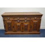 AN EARLY 20TH CENTURY CARVED OAK SIDEBOARD, foliate and lunette decoration, four drawers with lion