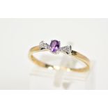 A 9CT GOLD AMETHYST AND DIAMOND RING, designed with a claw set oval cut amethyst flanked with single
